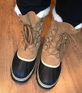 a reviewer wearing the same boots in tan with a black toe cap 