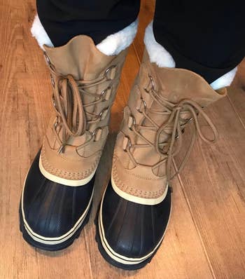 a reviewer wearing the same boots in tan with a black toe cap 