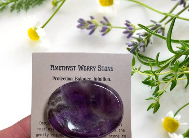 hand holding the amethyst worry stone