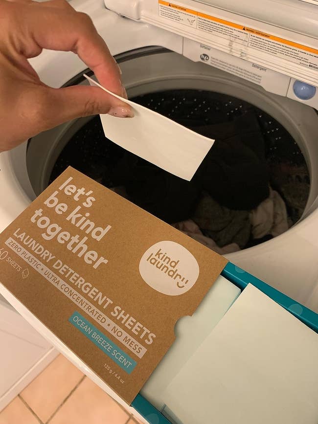 image of reviewer placing laundry detergent sheet into washing machine