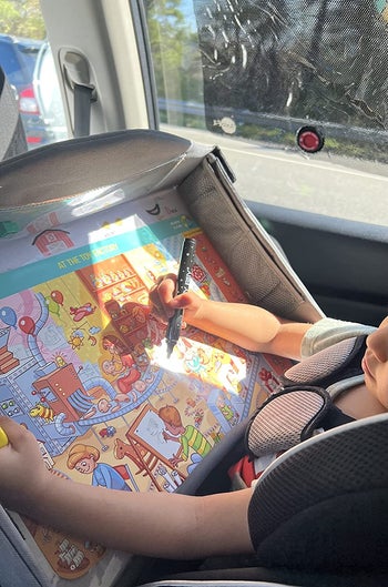 A child using the activity mat in the car