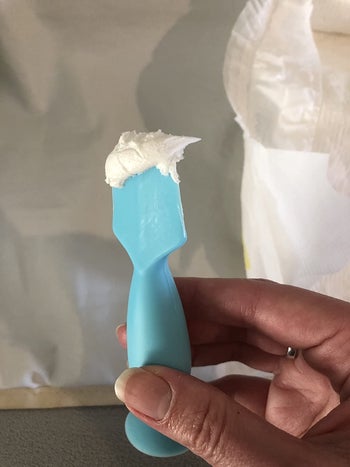 reviewer showing the thickness of the cream on an applicator
