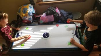 kids playing with the air hockey table 