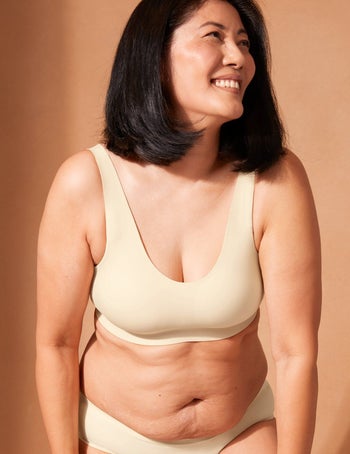 a model posing in a beige pullover bralette and matching panties