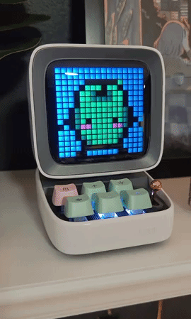 BuzzFeed editor's small speaker with a screen that has a dancing frog pixel graphic and a small keyboard with six keys