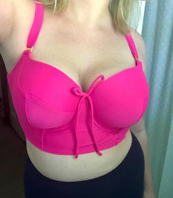 a reviewer wearing the swim top in pink 