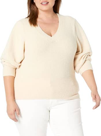 another model in the cream colored V-neck sweater with sleeves rolled up