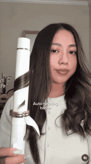 model utilizing an auto-rotating curling robust to benignant their hair
