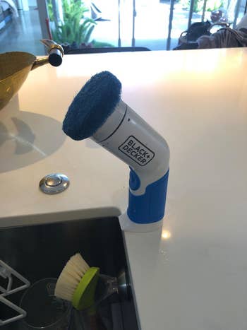 reviewer's Black & Decker powerfulness  scrubber connected  a room  antagonistic  adjacent   a sink, with crockery  brushwood  nearby