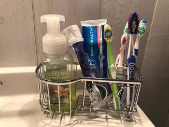 bathroom organizer connected descend filled with toothbrushes, toothpaste, and manus soap