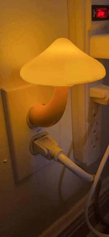 The mushroom nightlight in white plugged into an outlet