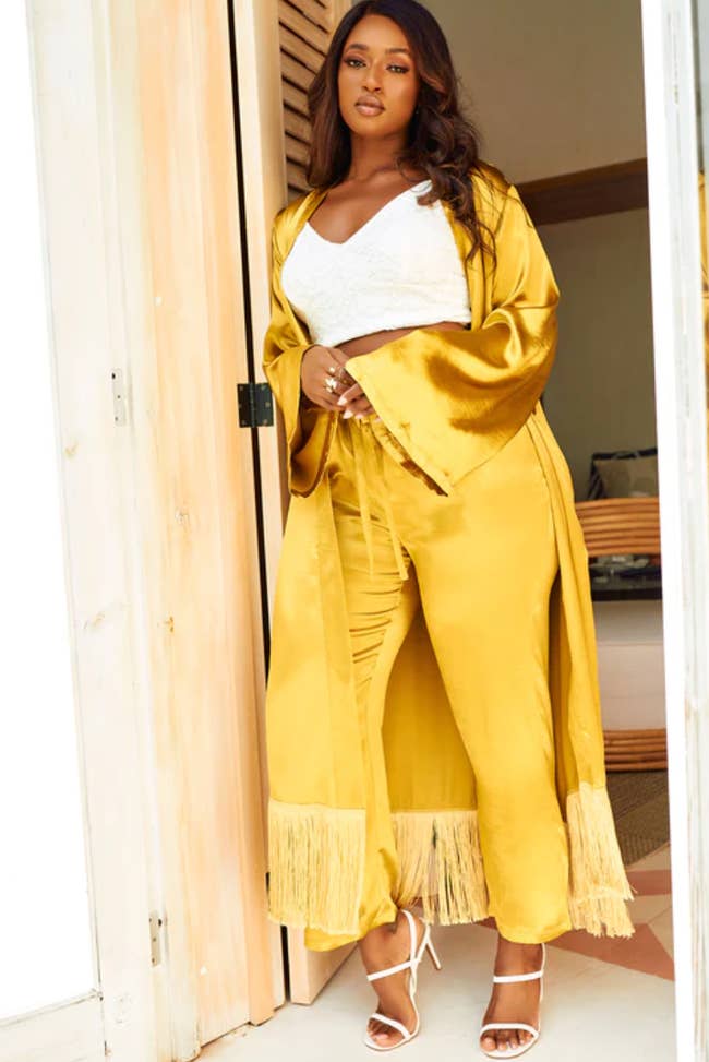 A model wearing a mustard-colored duster with matching pants