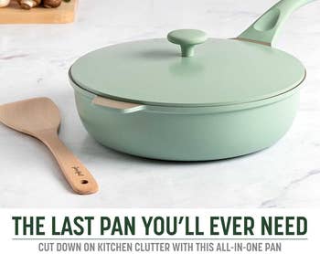 A mint-green non-stick frying pan with a lid and a wooden spatula on a kitchen counter