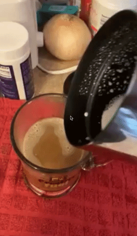 Reviewer pouring hot milk into cup of coffee with product