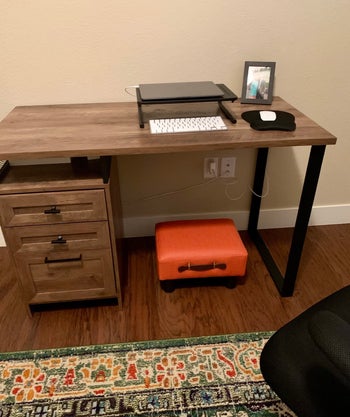 reviewer image of orange footstool under a desk