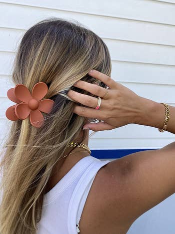 Reviewer wearing terra-cotta flower-shaped clip in hair