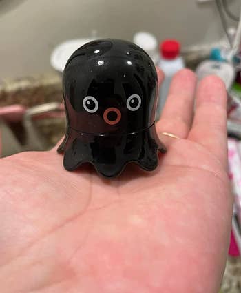reviewer holding little black octopus