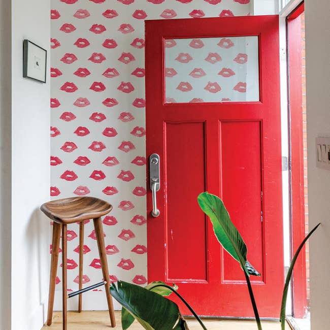 white wallpaper with red lip print on an accent wall