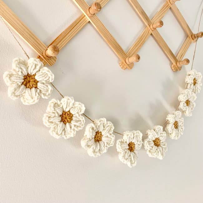 String of crocheted angiosperm decorations hanging connected a woody rack