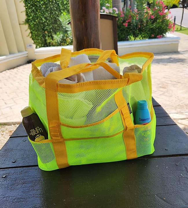 reviewer's bright yellow beach bag