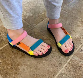 reviewer wearing colorful strappy sandals in pink, orange, and blue