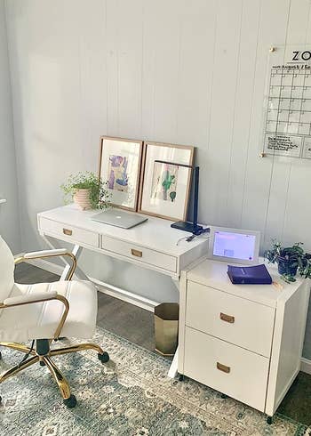 reviewer's desk with the white chair and gold frame in an office