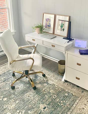 reviewer's desk with the white chair and gold frame in an office