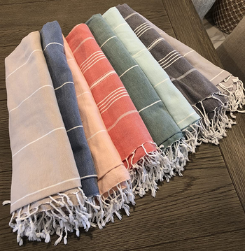 Reviewer image of eight different colored Turkish beach towels