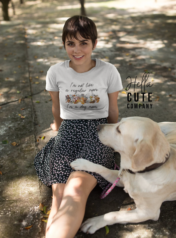 a model wearing a white tee that has a big group of disney dogs on it and the words 