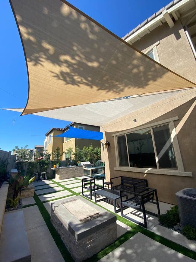 reviewer's backyard space covered by sail canopy