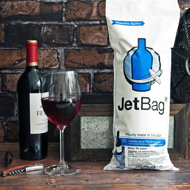the wine bag next to a bottle of wine and a wine glass 