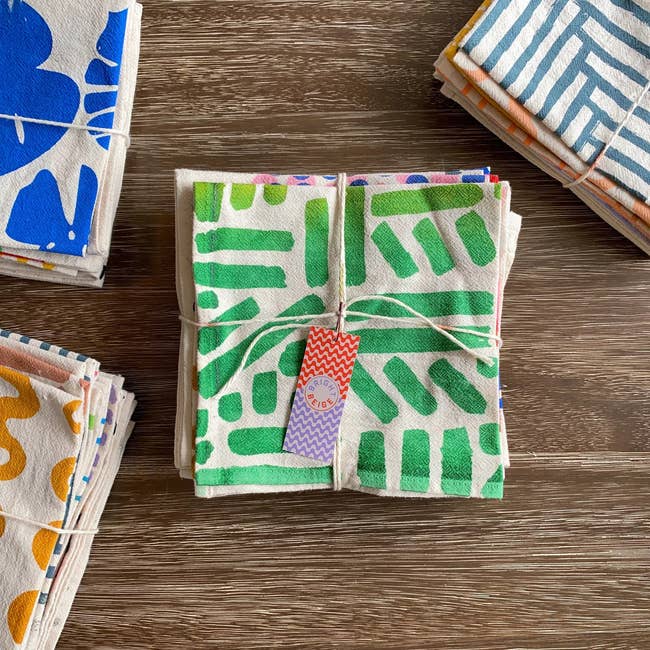 Stacked cloth napkins with vibrant patterns tied in a string