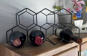 Reviewer image of the black geometric rack with bottles