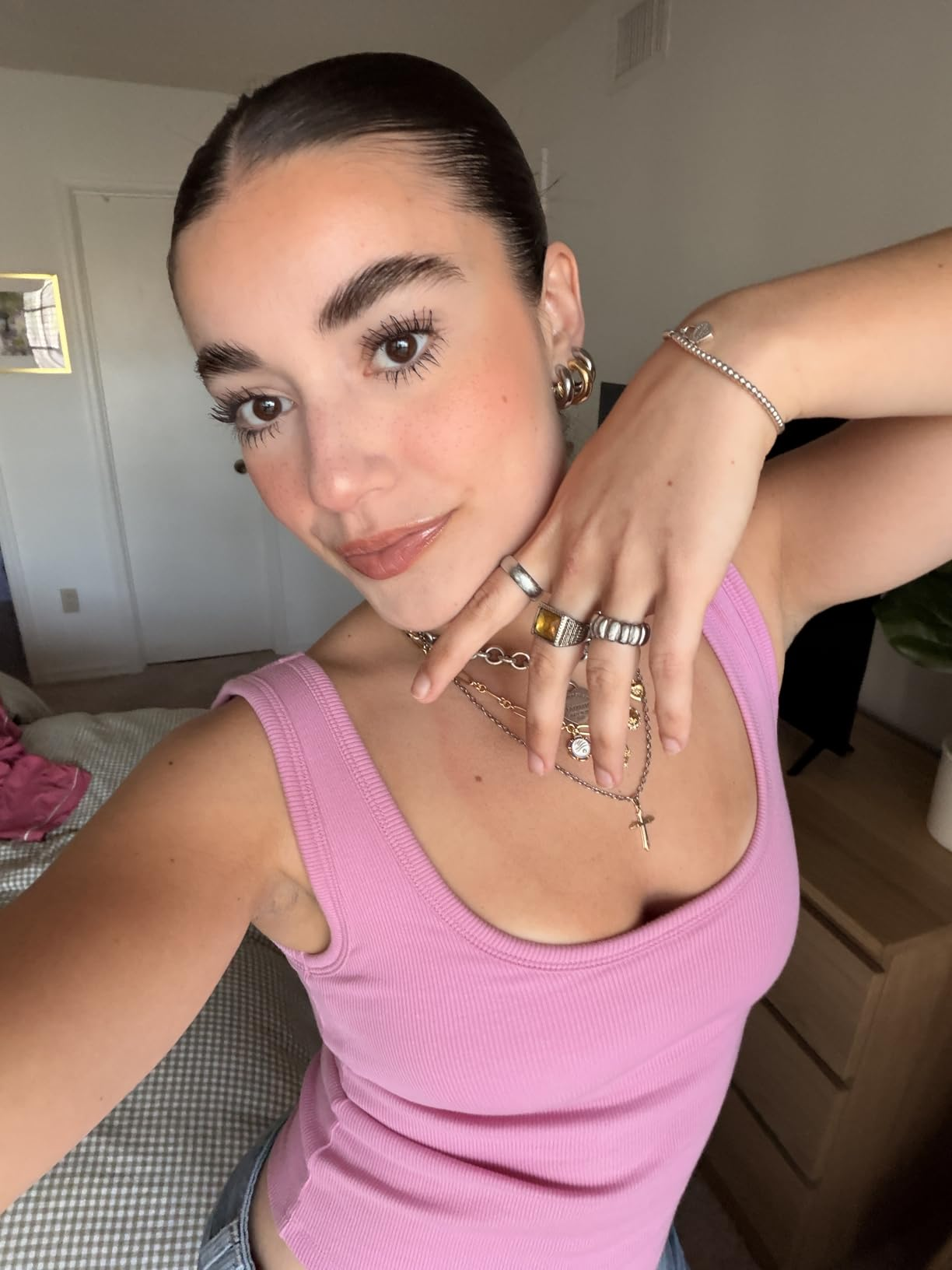 Person successful  a sleeveless apical  showing jewelry and makeup, posing indoors