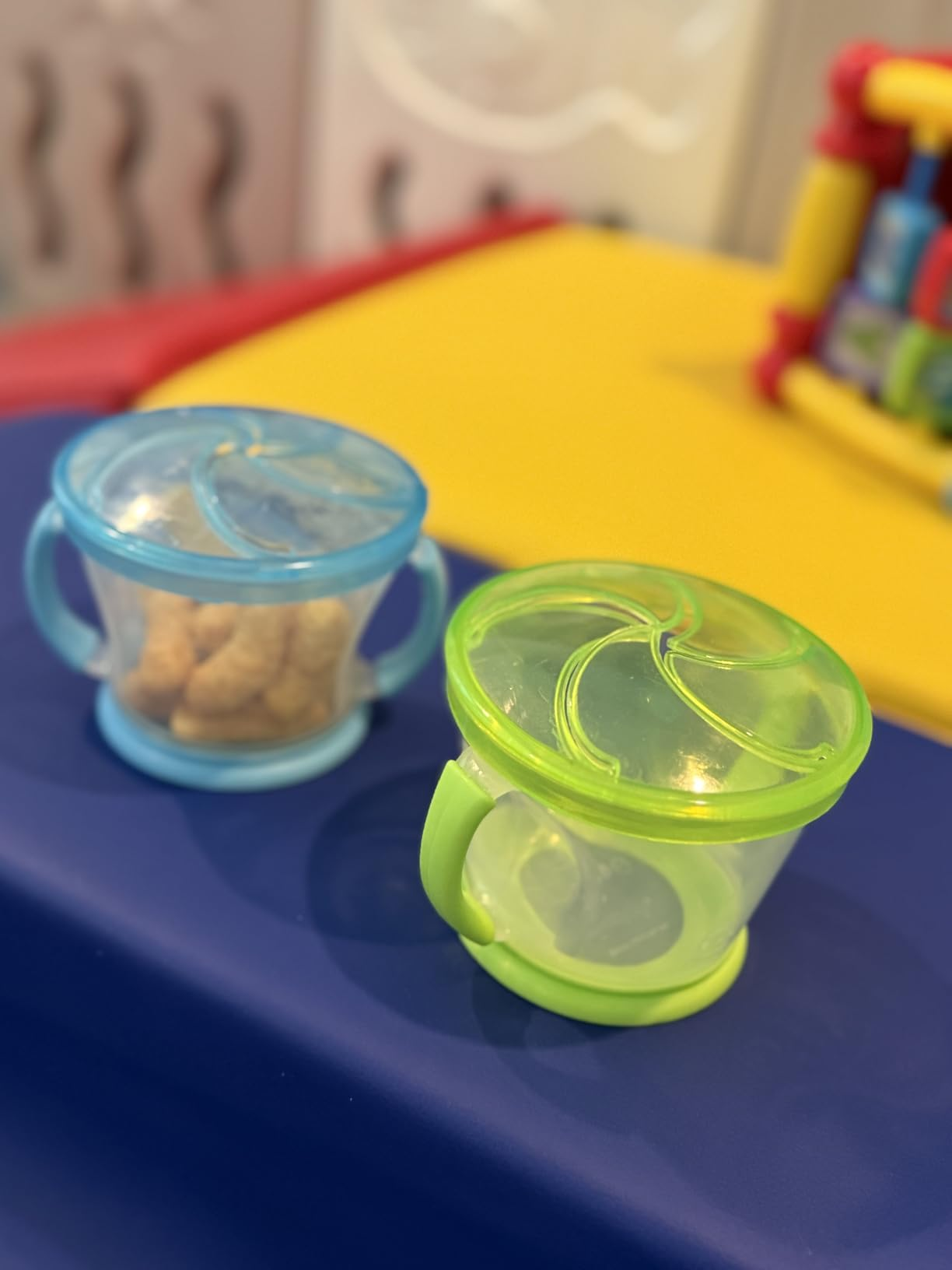 Two snack containers with lids connected  a table. One contains tiny  snacks, portion    the different   is empty. Perfect for on-the-go snacking