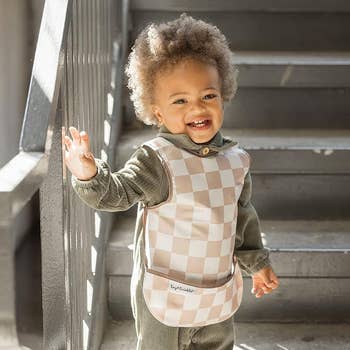 a child wearing the checkered apron bib
