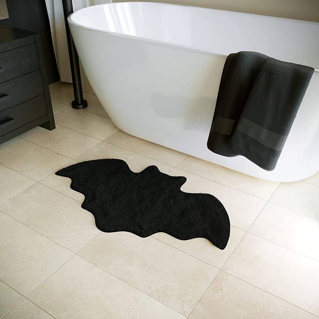 bat shaped bath mat in front of tub