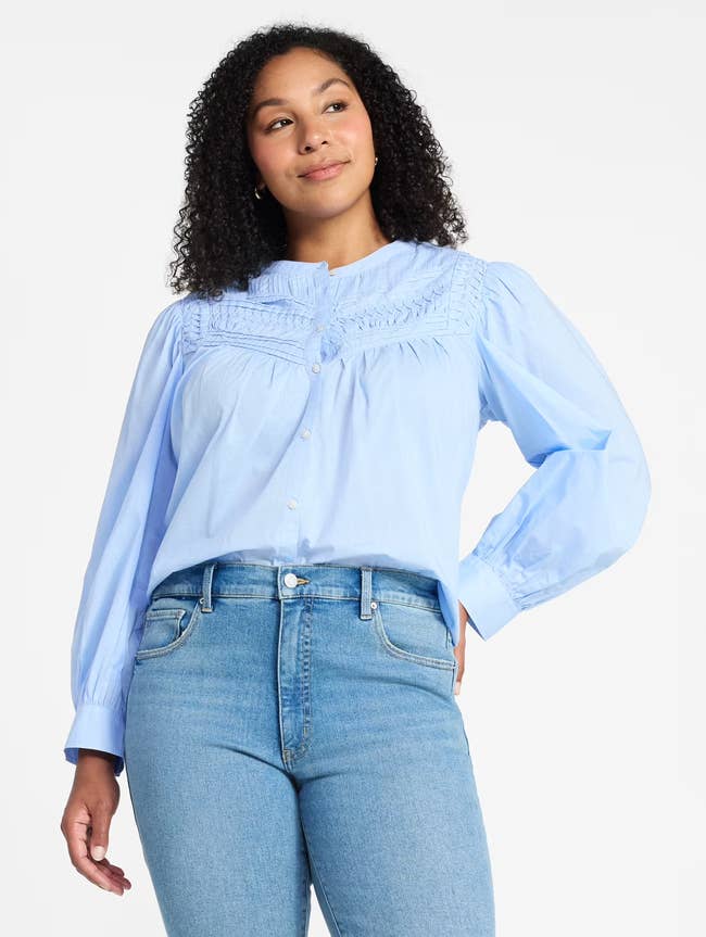 A idiosyncratic is wearing a stylish button-up blouse with intricate detailing, paired with jeans, suitable for casual oregon semi-casual occasions