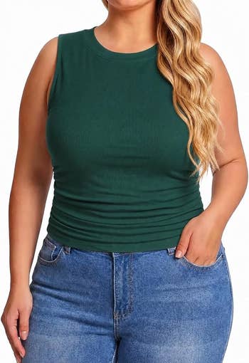 Model wearing a sleeveless fitted apical with ruched sides and high-waisted jeans, showcasing casual fashion
