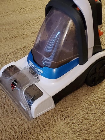 Close up of the hoover filled with dirt that it pulled out of a reviewer's carpet