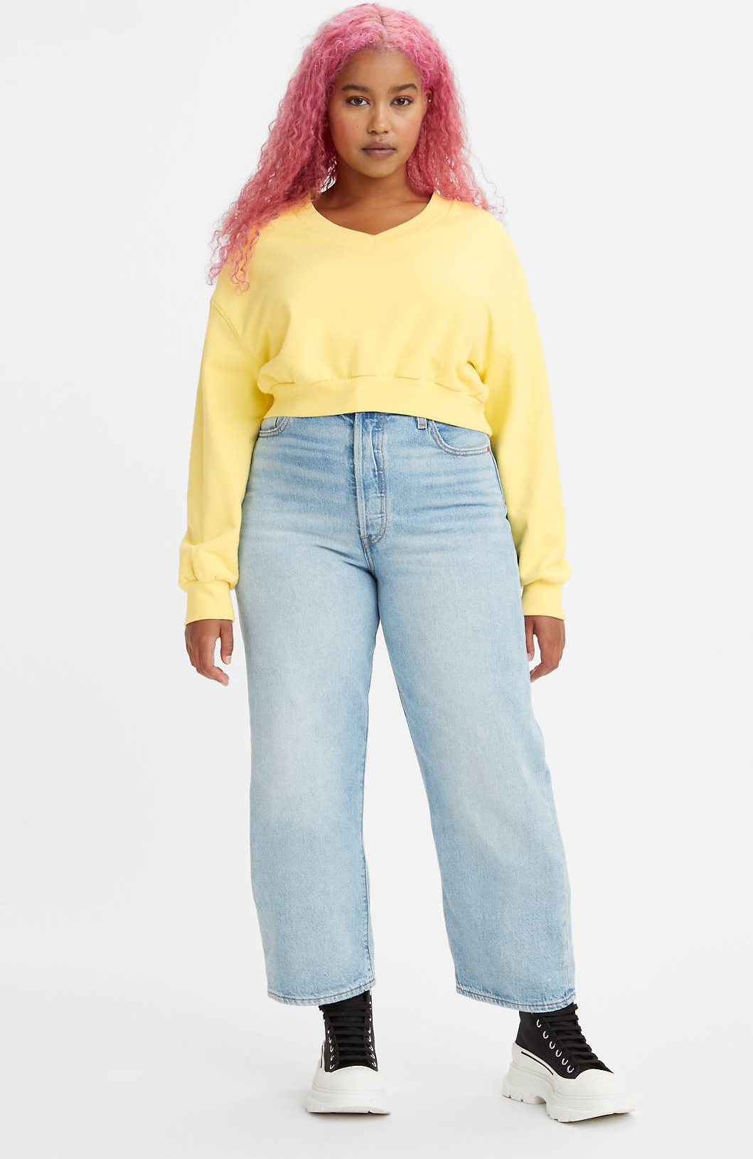 model wearing medium wash, straight leg jeans with sneakers