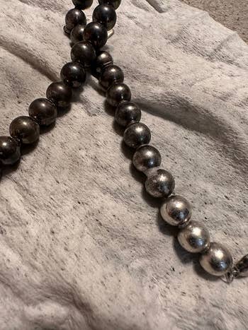 Close-up of metallic beaded necklace with varying shades