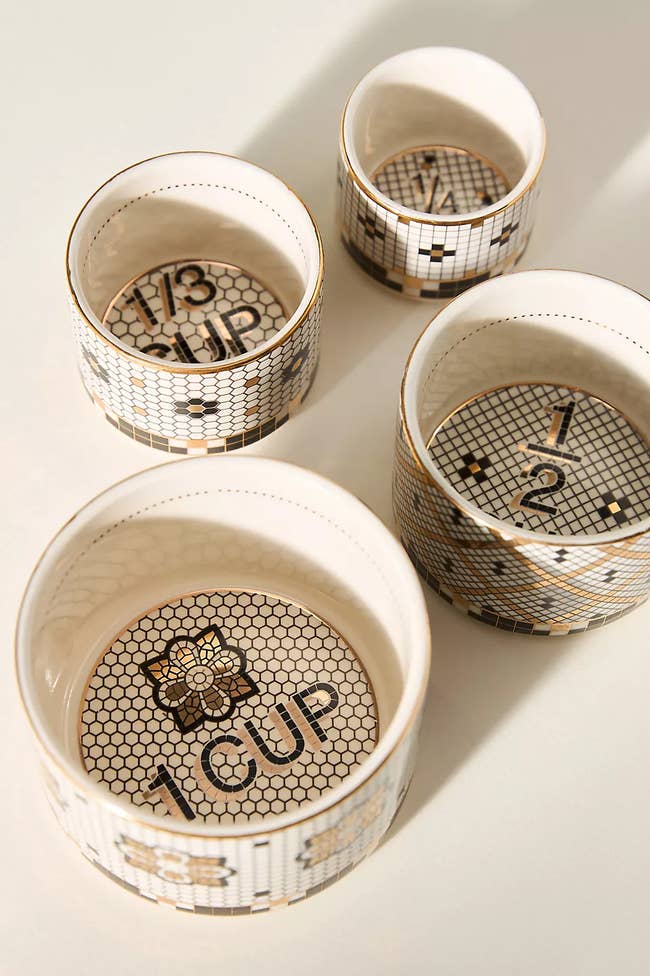 Set of 4 ceramic measuring cups with geometric pattern, labeled 1 cup, 1/2 cup, 1/3 cup, and 1/4 cup, featuring decorative interior designs