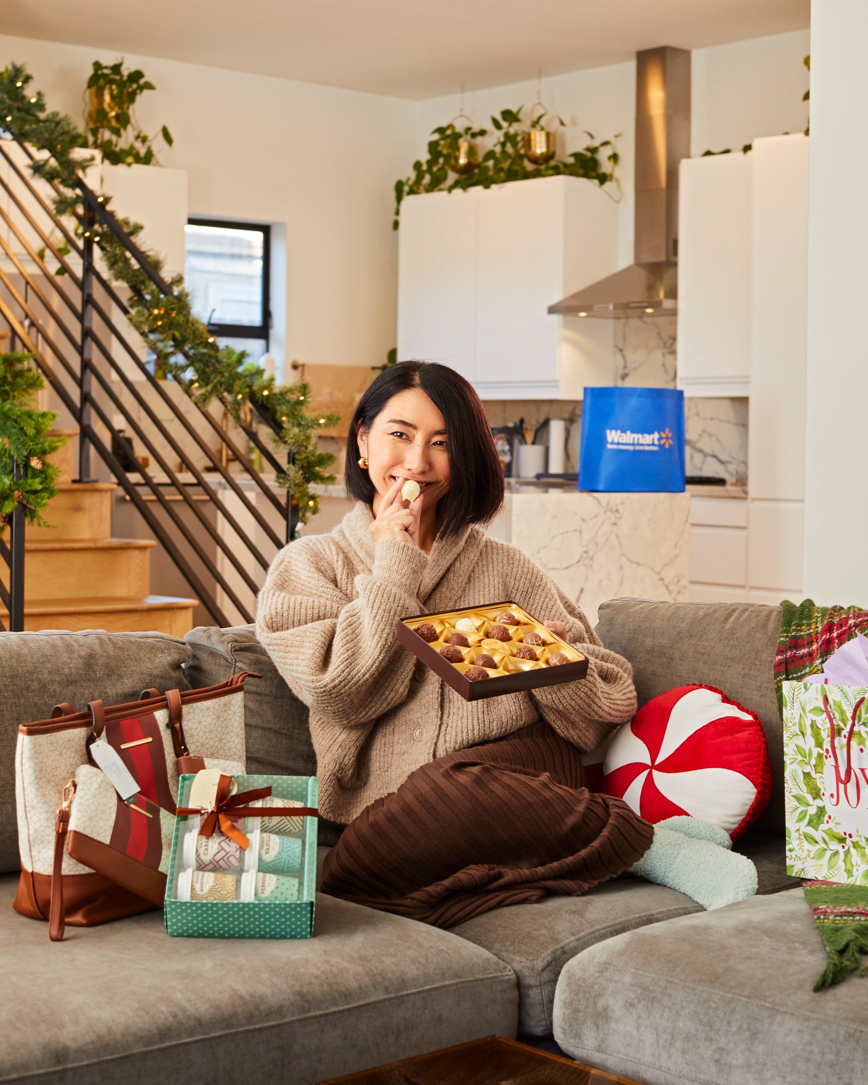 Rie eats chocolates on couch in living room with bag and coffee cups next to her