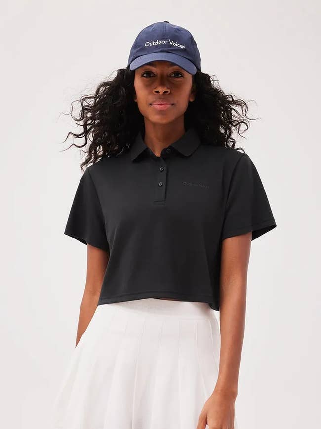 a model wearing the polo in black 