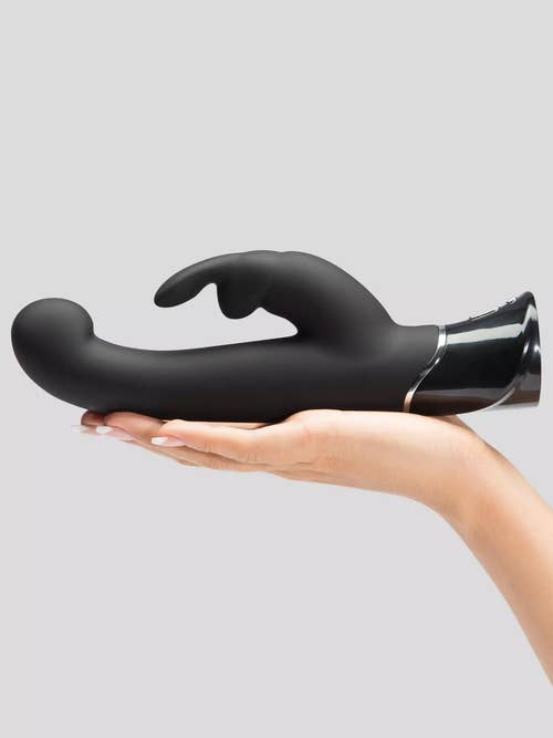 Model holding black rabbit vibrator flat in palm