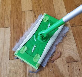 reviewer using the sheet with a Swiffer duster