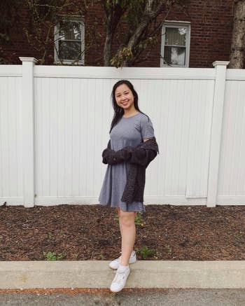 reviewer wearing the dress in grey with sneakers and a cardigan