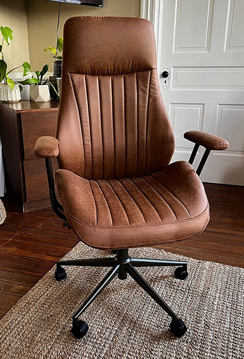 a reviewer photo of the faux leather chair in brown 