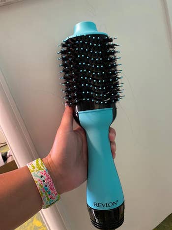 pic of reviewer holding blue one-step drying brush in their hand